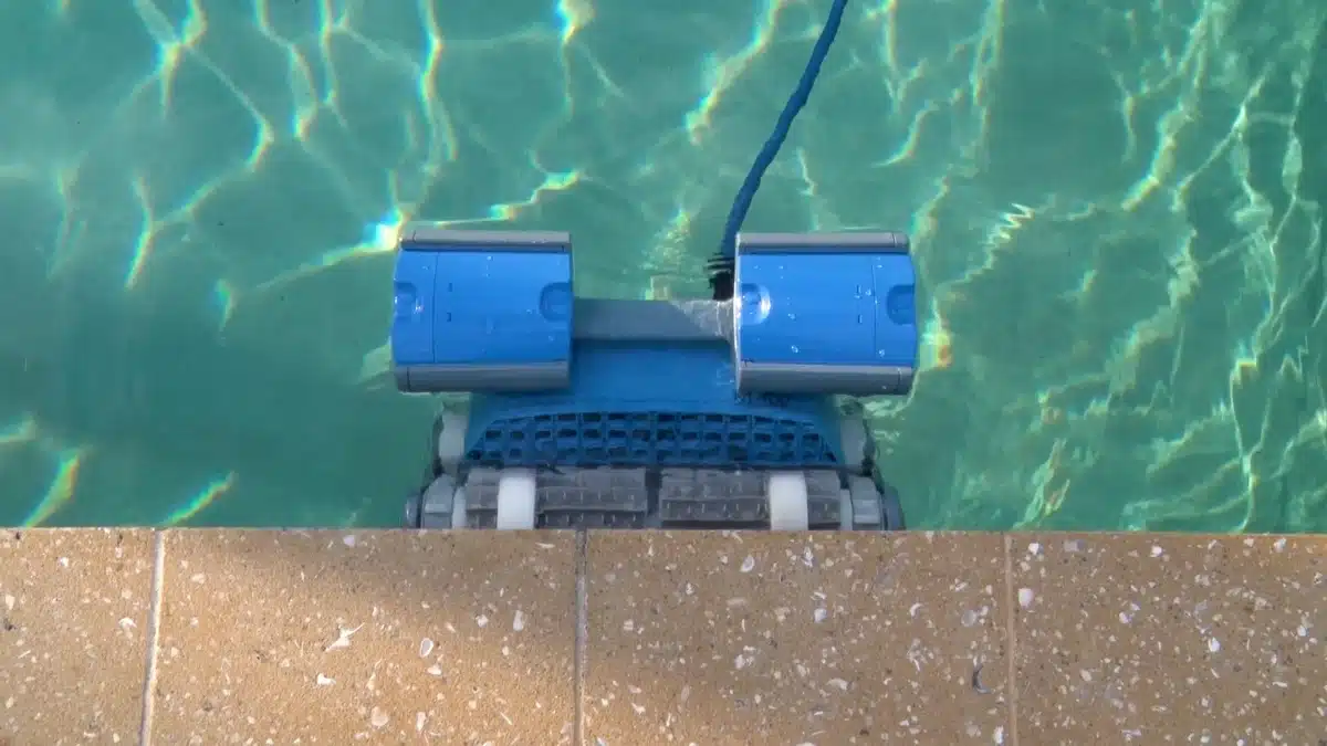 Robotic pool cleaner scrubbing the waterline to reduce manual vacuuming